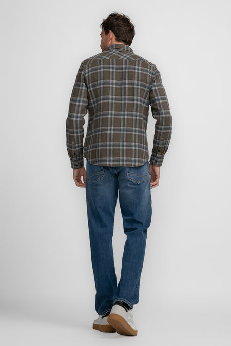 Chemise brune à longues manches de Petrol Industries, avec un motif rayé et portée avec des jeans.