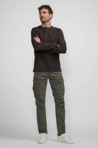 Pantalon de travail vert de Petrol Industries, avec des poches et des chaussures blanches.