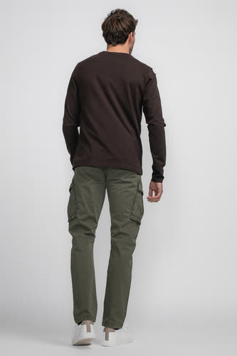 Pantalon de travail vert de Petrol Industries Industries Industriesu de derrière, associé à un t-shirt marron et des baskets blanches.