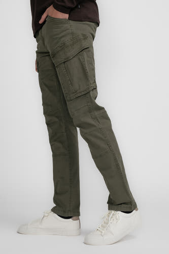 Pantalon de travail vert de Petrol Industries, avec des poches et des baskets blanches, en vue latérale.