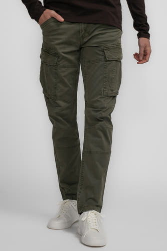 Pantalon de travail vert de Petrol Industries, avec plusieurs poches et porté avec des baskets blanches.