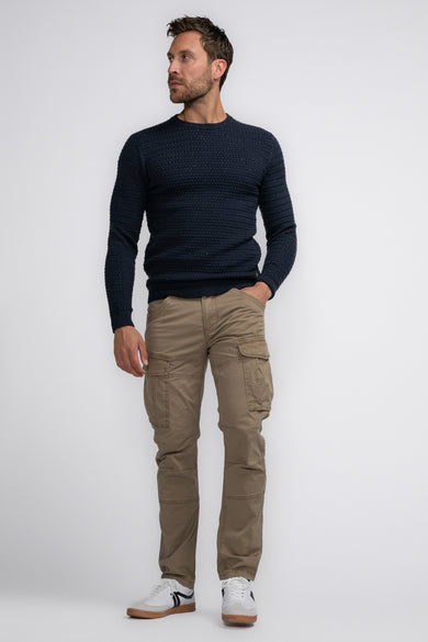Pantalon cargo Bruine de Petrol Industries® avec grandes poches, porté avec un pull bleu foncé et des baskets blanches, vue en pied complète.