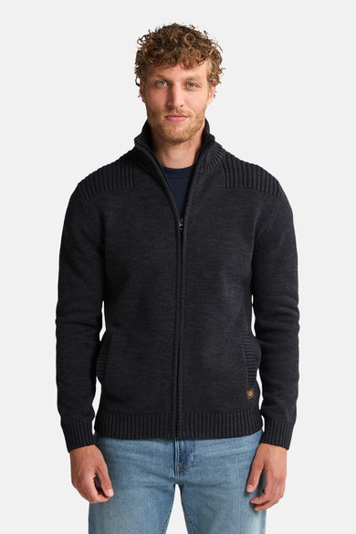 Gilet noir de Petrol Industries, avec fermeture à glissière et structure côtelée sur les épaules, associé à un jean bleu.