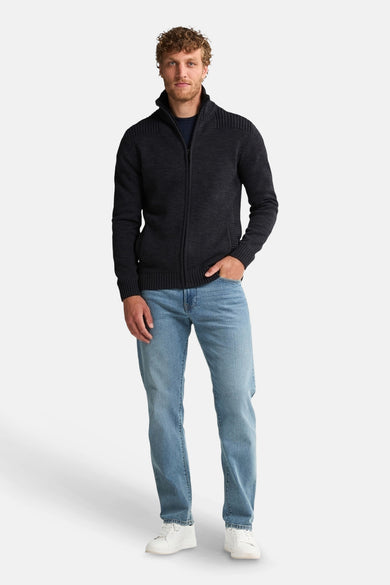 Gilet noir de Petrol Industries®, porté avec un t-shirt bleu et des jeans, des baskets blanches.