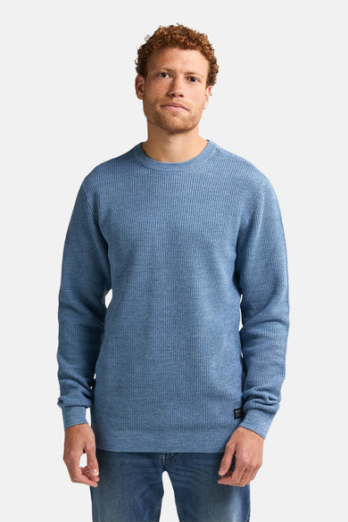 T-shirt bleu avec col rond de Petrol Industries, à un fin motif rayé, porté avec des jeans.
