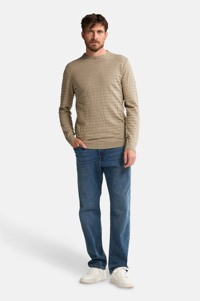 Gilet beige avec col rond de Petrol Industries, doté d'un motif subtil et porté avec des jeans et des baskets blanches.