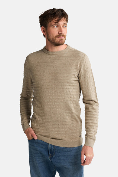 Gilet beige avec col rond de Petrol Industries®, rayé et porté avec un jean.