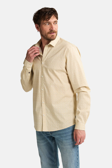 Chemise beige à manches longues de Petrol Industries®, avec un motif subtil, associée à des jeans.