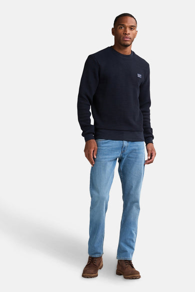 T-shirt bleu avec col rond de Petrol Industries®, doté d'une subtile texture et associé à des jeans et des chaussures marrons.
