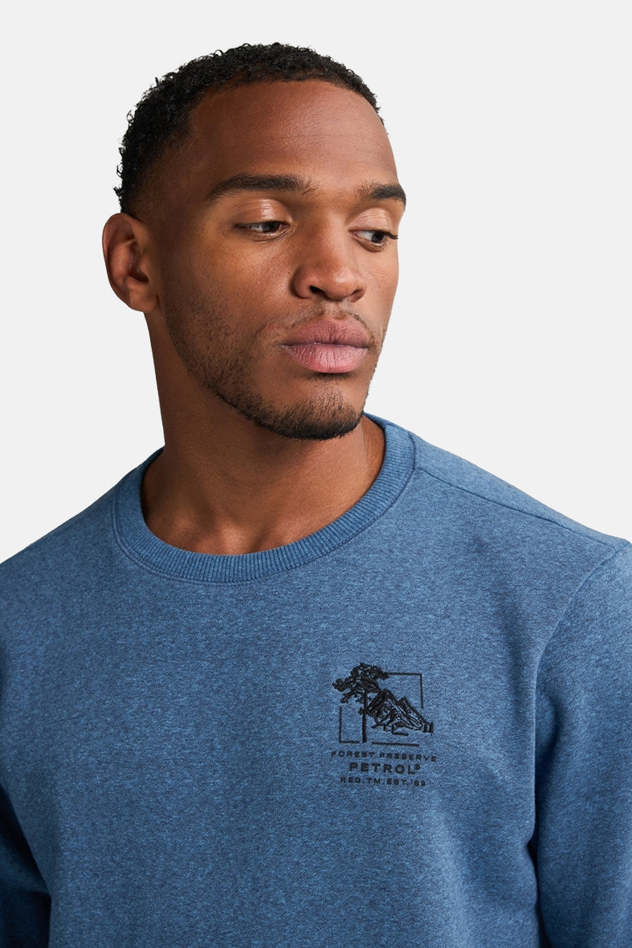 Gilet bleu de Petrol Industries avec un col rond et un petit logo graphique sur la poitrine.