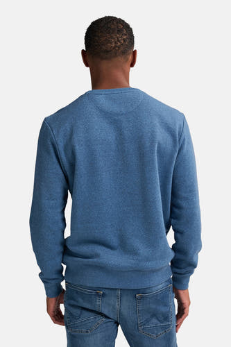 Pull-over bleu de Petrol Industries® avec des manches longues et un col rond, vu de dos, associé à des jeans.
