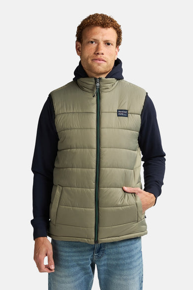 Gilet bodywarmer de Petrol Industries avec fermeture éclair, poches et une hoodie bleu foncé en dessous.