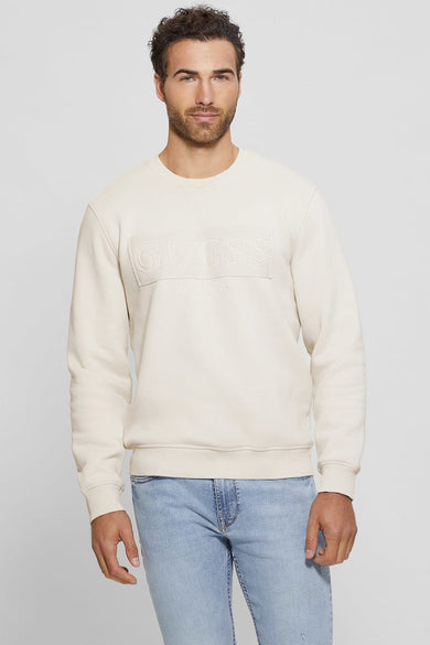 Pull écru Guess avec un logo Guess en relief et 'Established 1981' sur la poitrine.