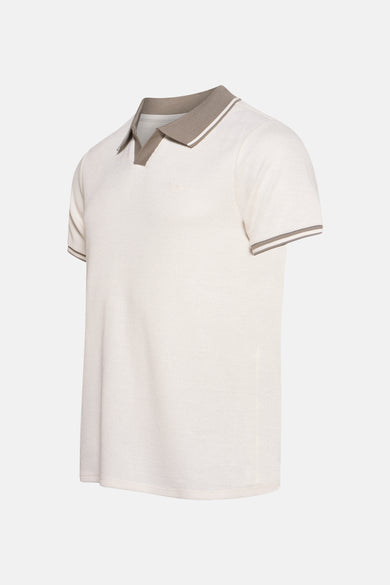 Polo beige à manches courtes de Guess, avec des détails marrons au col et aux manches.