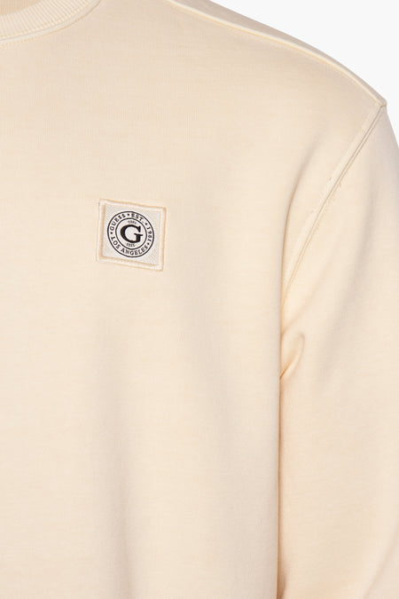 Lichtgele sweater met ronde hals van Guess® met fijne gebreide textuur en logo-patch op de borst.