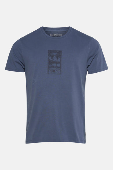 T-shirt bleu à manches courtes de Guess, avec une impression graphique de palmiers.