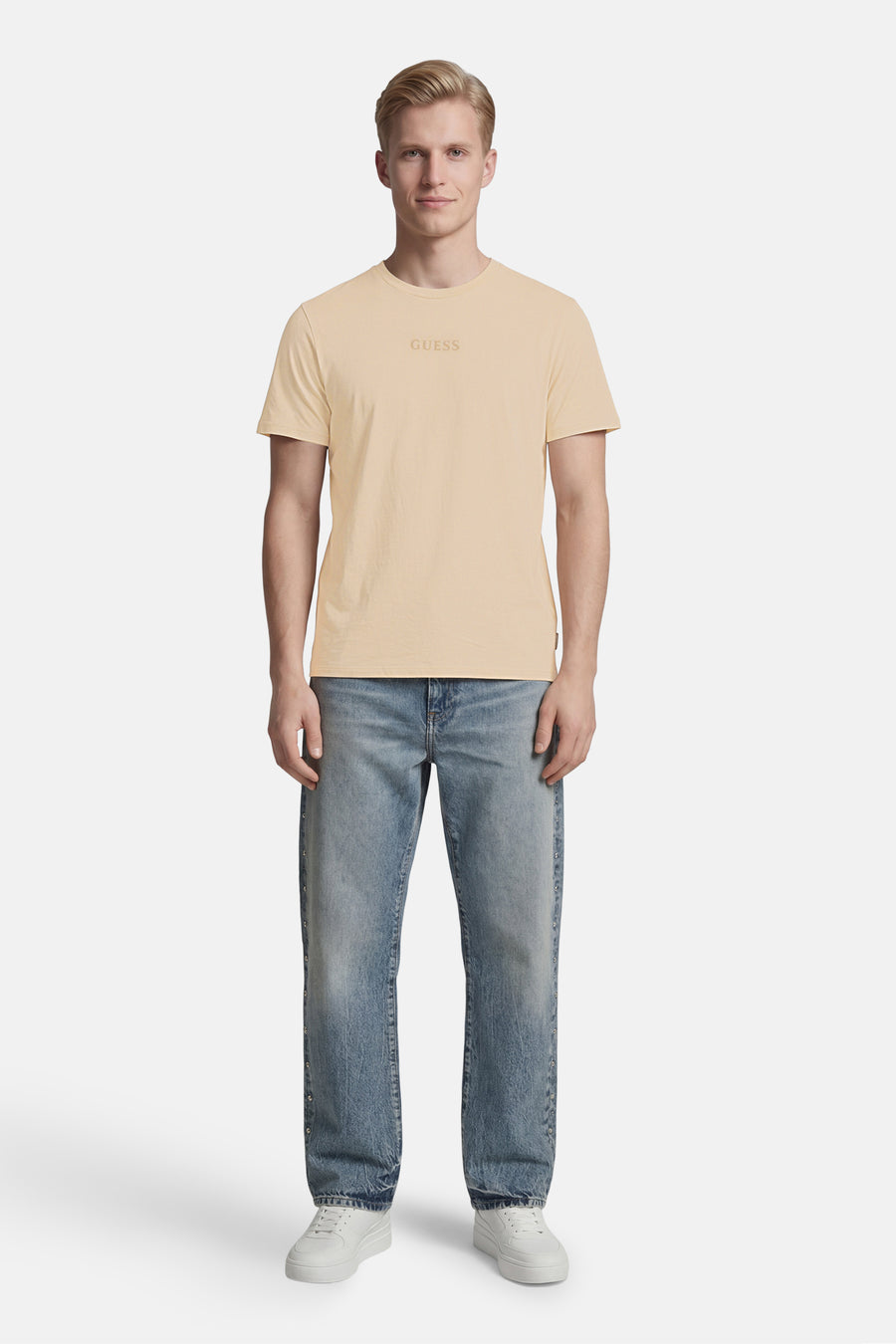T-shirt beige de Guess avec un logo 'GUESS' discret sur la poitrine.