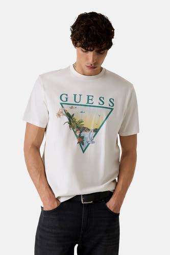T-shirt blanc Guess avec un imprimé graphique triangulaire d'une scène tropicale sur le devant.