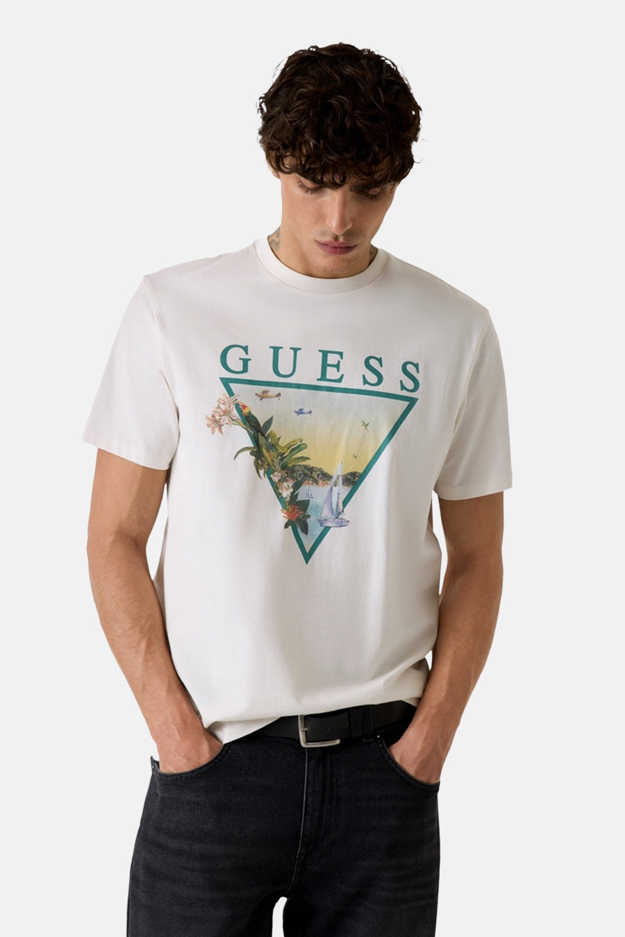 T-shirt blanc Guess avec un imprimé graphique triangulaire d'une scène tropicale sur le devant.