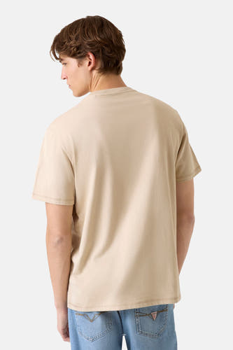 T-shirt beige à manches courtes de Guess, vu de dos, combiné avec un jean bleu.