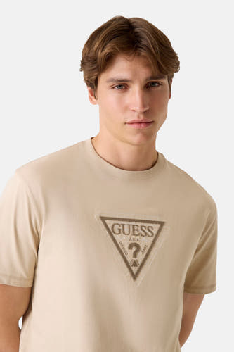 T-shirt beige à manches courtes de Guess, avec un imprimé logo sur la poitrine.