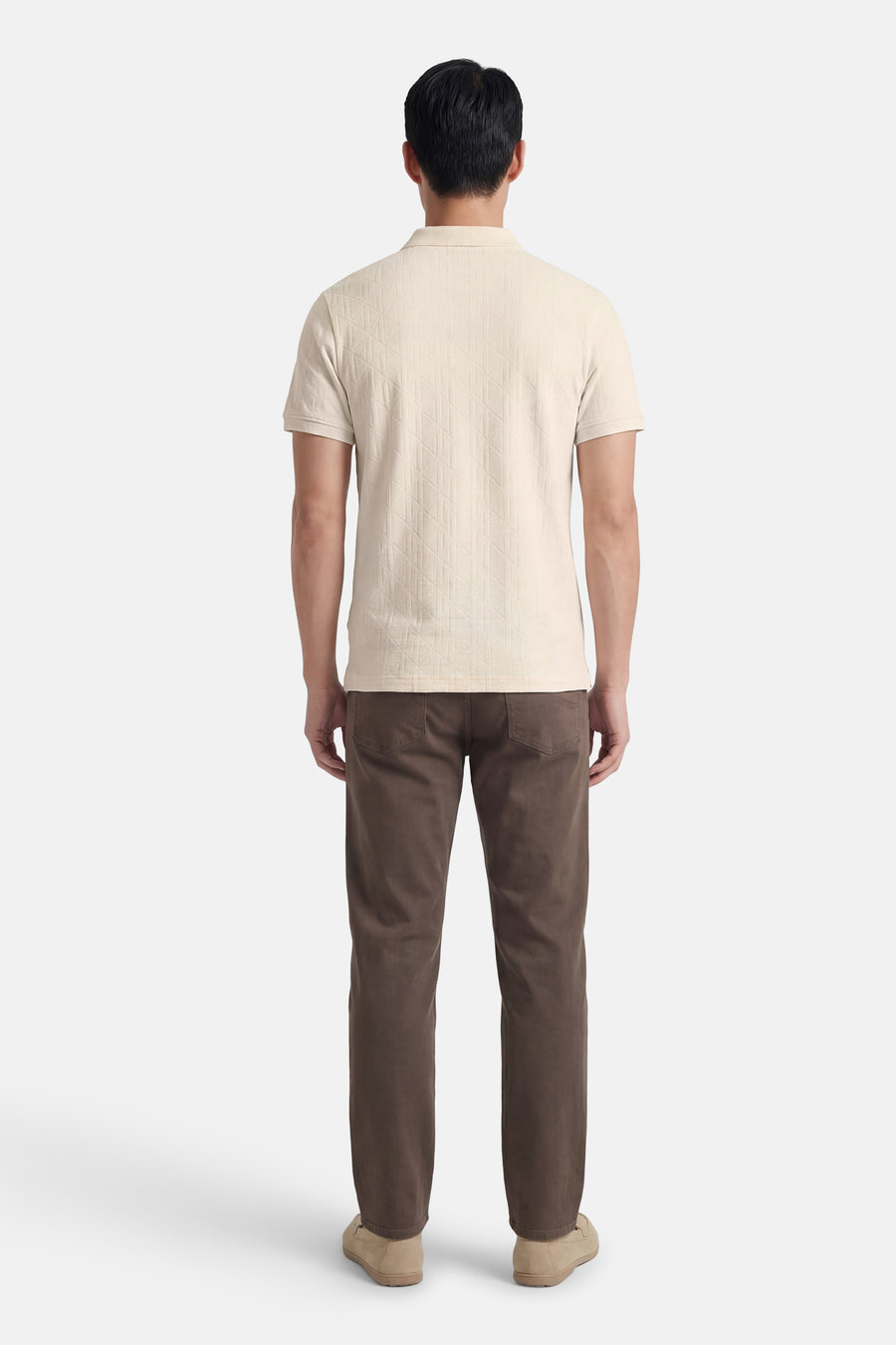 Polo marron de Guess, avec un motif géométrique subtil et portée avec un pantalon en velours côtelé marron et des mocassins en daim.