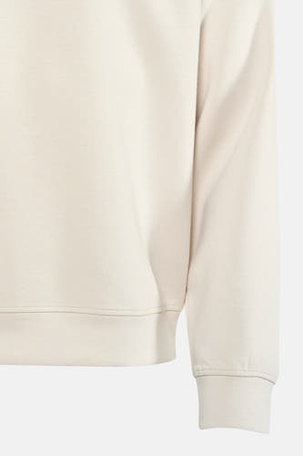 Gilet beige de Guess, gros plan sur le bas et la manche.