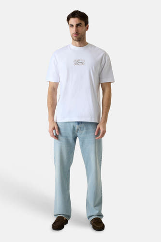 Witte korte mouwen t-shirt met klein logo op borst, van Guess, gedragen met lichtblauwe jeans en bruine loafers, front view.