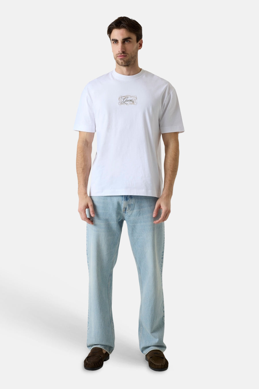 Witte korte mouwen t-shirt met klein logo op borst, van Guess, gedragen met lichtblauwe jeans en bruine loafers, front view.