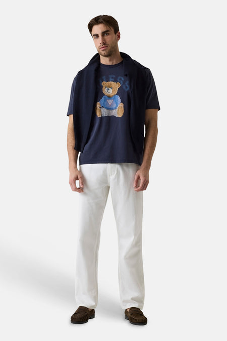 Donkerblauwe korte mouwen T-shirt met teddybeerprint van Guess, gedragen met witte broek en bruine loafers, front view