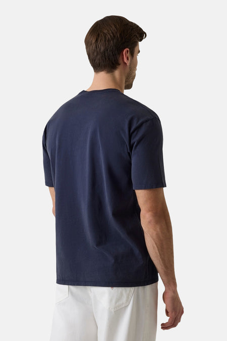 Donkerblauwe korte mouwen T-shirt van Guess®, achterzijde weergegeven, eenvoudig design, comfortabele pasvorm, model draagt witte broek.