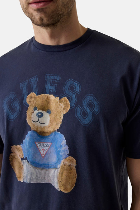 Donkerblauwe korte mouw T-shirt van Guess met teddybeer print en logo, close-up op borst.