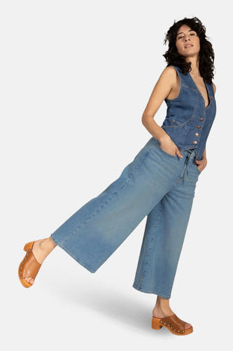 Lichtblauwe denim jeans wide van Lee Cooper, met wijde pijpen en bruine muiltjes.
