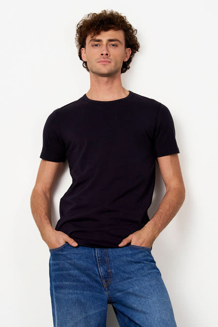 Zwart T-shirt met korte mouwen van Le Fabuleux Marcel de Bruxelles, effen en met ronde hals, gedragen in blauwe jeans.