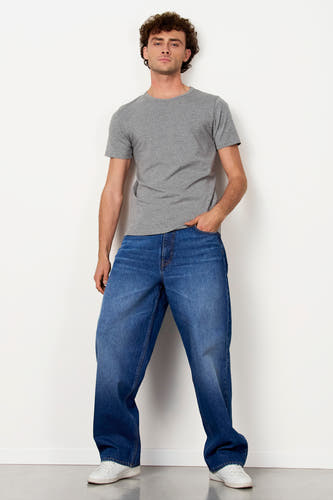 T-shirt gris de Le Fabuleux Marcel de Bruxelles, à manches courtes, associé à des jeans et des baskets blanches.