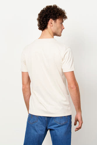 Wit T-shirt van Le Fabuleux Marcel de Bruxelles met lichte textuur en omgeslagen mouwen, achteraanzicht gedragen door een man met blauwe jeans.