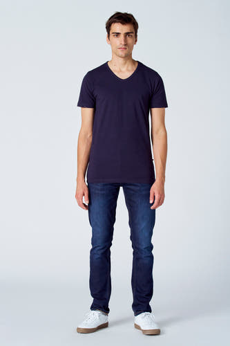 T-shirt bleu de Le Fabuleux Marcel de Bruxelles, porté avec des jeans foncés et des baskets blanches.