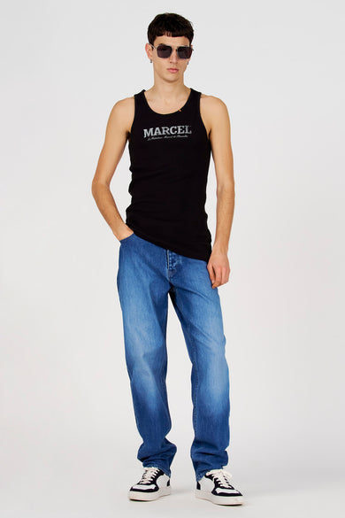 Débardeur noir de Le Fabuleux Marcel de Bruxelles, porté avec un jean et des baskets noires et blanches.