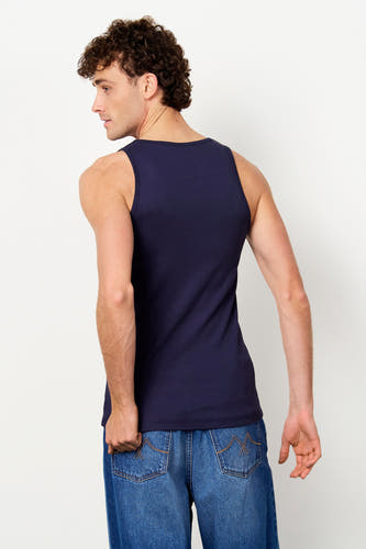Débardeur bleu côtelé de Le Fabuleux Marcel de Bruxelles, porté de dos par un homme avec un jean bleu.