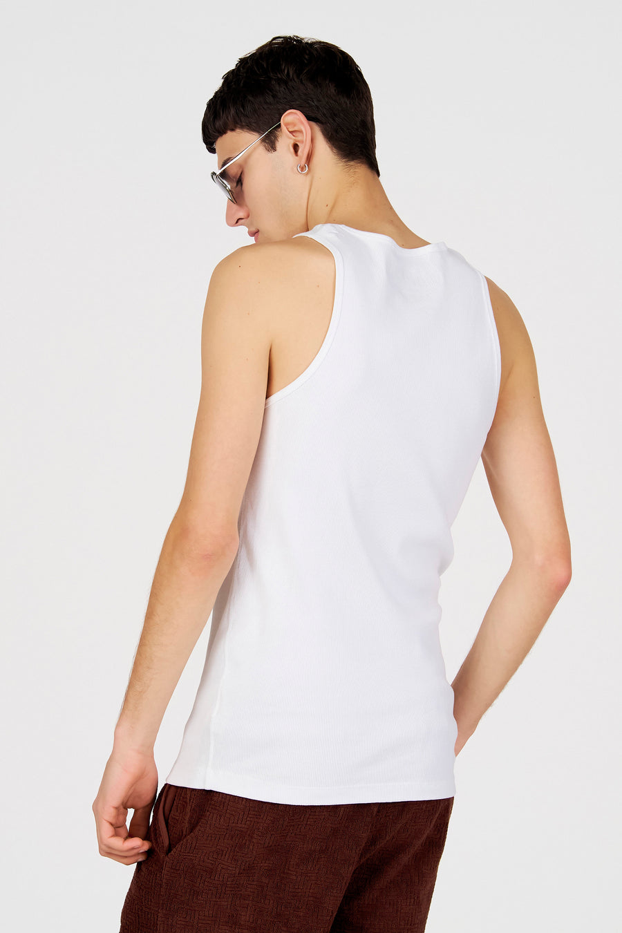 Wit tanktop van Le Fabuleux Marcel de Bruxelles, met een geribbelde textuur en gedragen met een bruine broek.