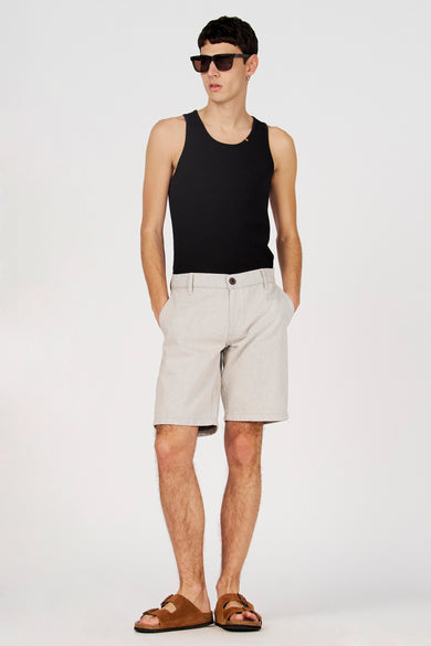 Débardeur noir de Le Fabuleux Marcel de Bruxelles, porté avec un short et des sandales.