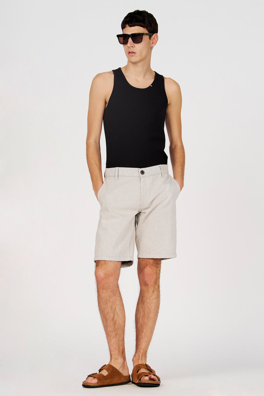 Débardeur noir de Le Fabuleux Marcel de Bruxelles, porté avec un short et des sandales.