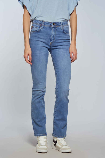 Jean bootcut en denim bleu clair de Le Fabuleux Marcel de Bruxelles, avec un style décontracté et des baskets blanches.