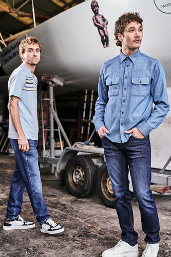 7/8 jeans en denim bleu moyen de Le Fabuleux Marcel de Bruxelles, portés avec un chemisier bleu et des baskets blanches.