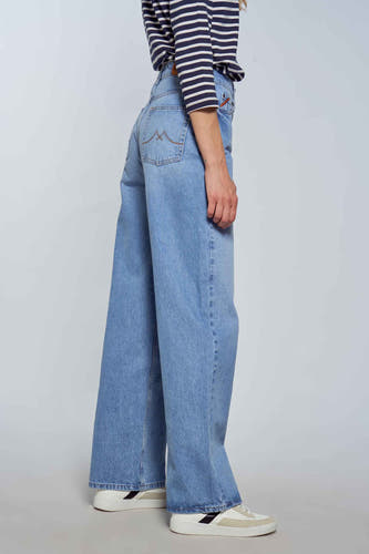 Jean large en denim bleu clair de Le Fabuleux Marcel de Bruxelles, avec des boutons décoratifs sur la poche arrière.