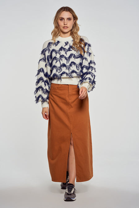 Jupe longue brune de Le Fabuleux Marcel de Bruxelles, fendue, associée à un pull avec un motif bleu.