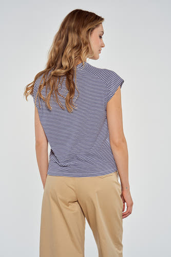 T-shirt bleu de Le Fabuleux Marcel de Bruxelles, avec des rayures horizontales, associé à un pantalon beige.