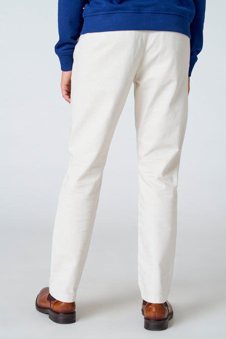 Witte broek van Le Fabuleux Marcel de Bruxelles, gezien van achteren, met bruine schoenen en een blauwe trui.
