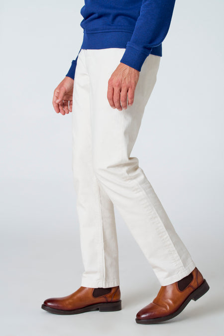 Pantalon blanc de Le Fabuleux Marcel de Bruxelles, avec un design simple et des bottes brunes.