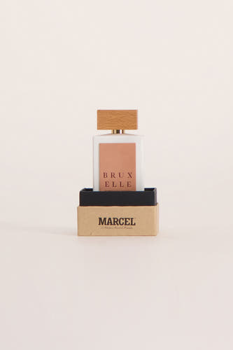Parfum multicolore de Le Fabuleux Marcel de Bruxelles dans un flacon carré avec un bouchon en bois, placé dans une boîte.
